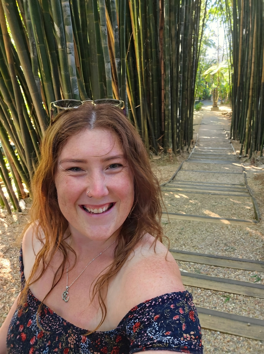 Caitie smiling on a bamboo-lined path